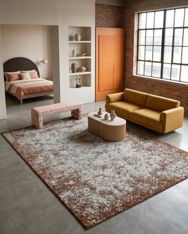 Rust and grey rug on concrete floor in a loft living room with a mustard sofa, pink bench and fluted oval coffee table